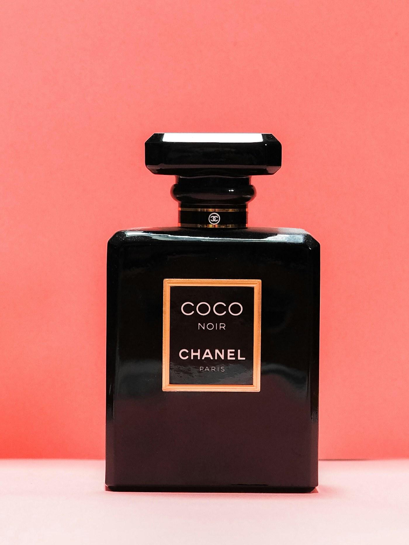 Editorial fragrance bottle in moody gold and ink lighting